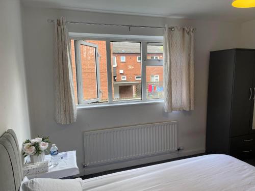 een slaapkamer met een bed en een raam bij Homestays-Close to Coventry City and University I Free Parking I Wi-Fi in Coventry