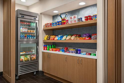 a kitchen with an open refrigerator and lots of food at Holiday Inn Express Hotel & Suites McDonough by IHG in McDonough