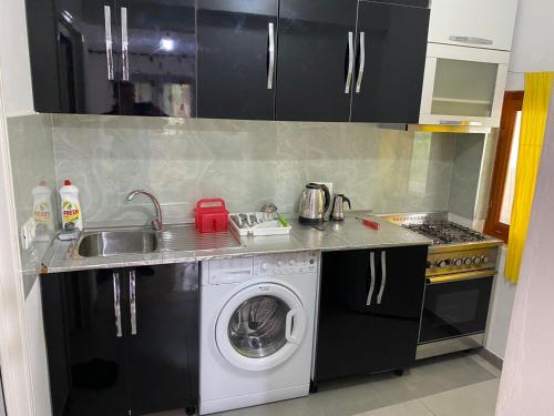 a kitchen with a washing machine and a sink at Feriz Vukaj in Hamallë