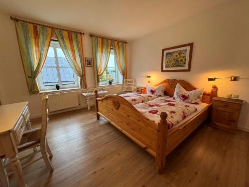 - une chambre avec un lit en bois et un bureau dans l'établissement Land-gut-Hotel Lohmann, à Drensteinfurt