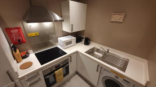 a small kitchen with a sink and a microwave at The Savile - Luxury Apartment Leeds - Your Next Stay in Leeds
