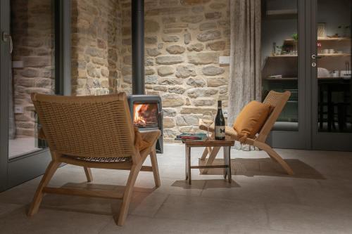 two chairs and a table with a fireplace at B&B Panfilo Farmhouse in Cellino Attanasio