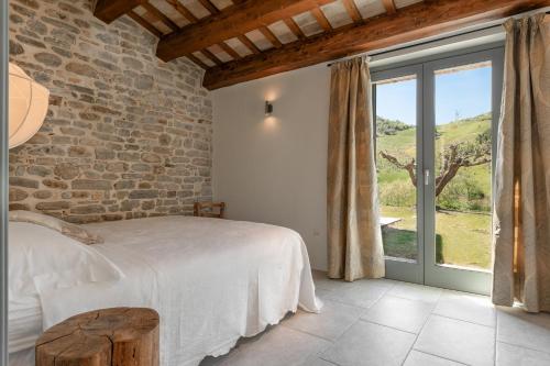 a bedroom with a bed and a large window at Panfilo Farmhouse in Cellino Attanasio