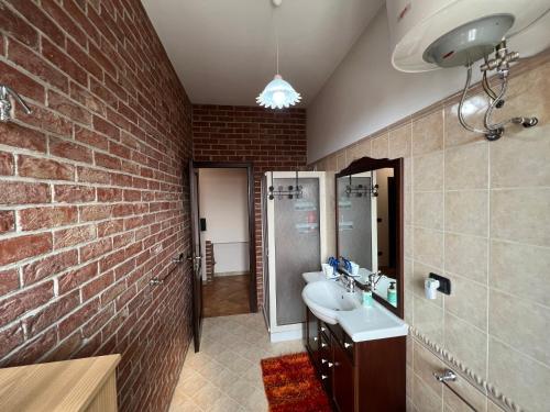 a bathroom with a sink and a brick wall at B&B EMPIRA Lamezia Terme in Lamezia Terme