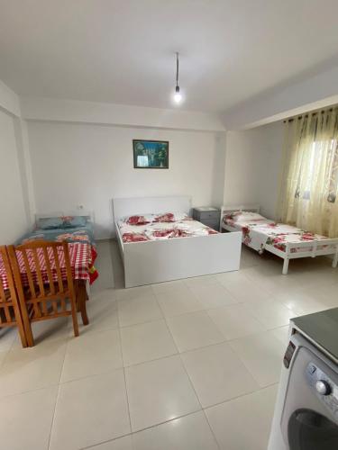 a bedroom with two beds and a table and chairs at Feriz Vukaj in Hamallë