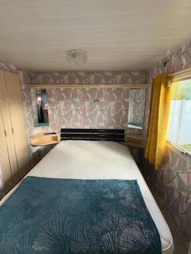 una cama en la parte trasera de una caravana en Mobil-home en Brêmes