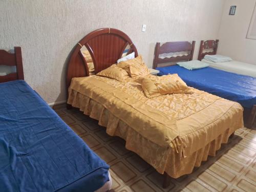 a bedroom with two beds with blue sheets at Casa da maci in Mauá