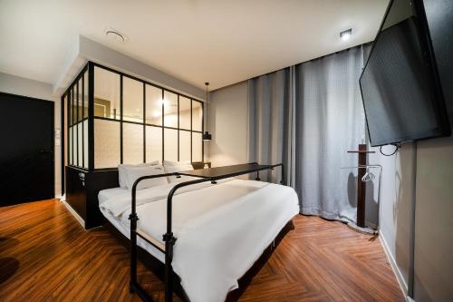 Schlafzimmer mit einem Bett mit weißer Bettwäsche und einem Fenster in der Unterkunft 2 Heaven Hotel Songdo in Busan