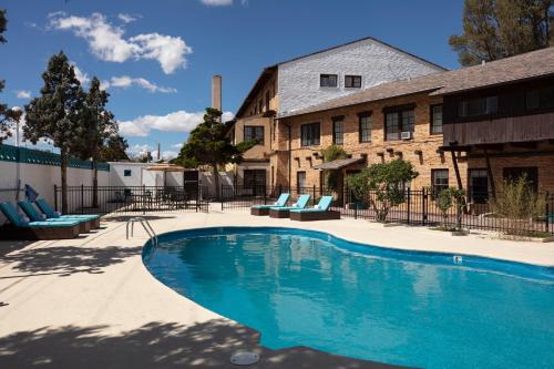 a swimming pool in front of a building at Hotel El Rancho in Gallup