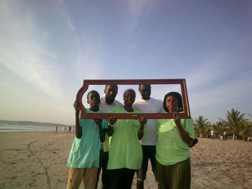 a group of people holding a picture frame on the beach at MANGROVE BEACH in Sanyang