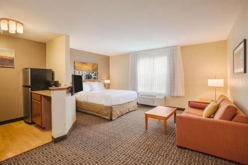 a hotel room with a bed and a couch at TownePlace Suites Houston Northwest in Houston