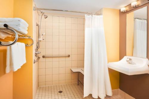 TownePlace Suites Houston Northwest في هيوستن: حمام مع دش ومغسلة