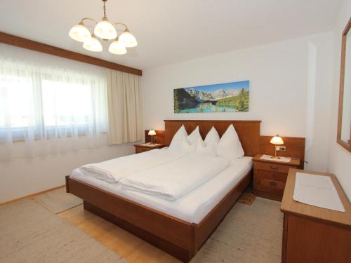 um quarto com uma cama grande e lençóis brancos em Schleicherhof IV em Strass im Zillertal