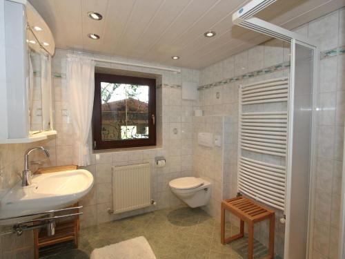 uma casa de banho com um lavatório, um WC e uma janela. em Schleicherhof IV em Strass im Zillertal