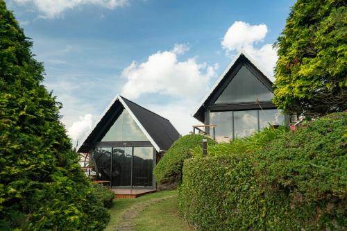 a house with a black roof and glass windows at Pousada das Pedras in Monte Verde