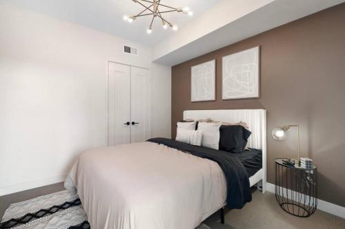 um quarto com uma cama branca e um lustre em Irvine Luxury & Modern Home em Santa Ana
