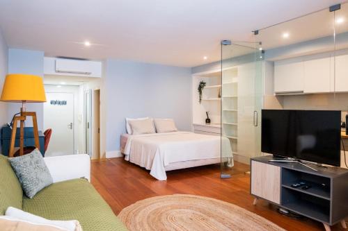 - un salon avec un lit et une télévision dans l'établissement Apartment in Santos, à Lisbonne