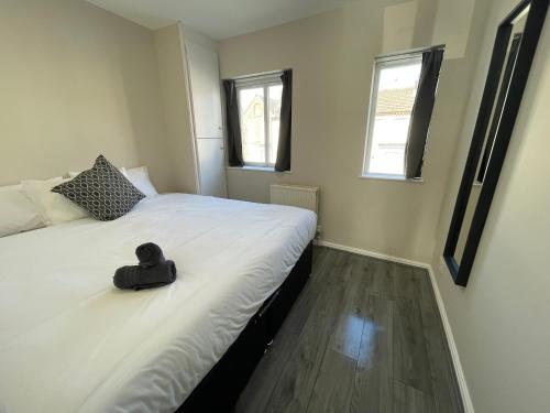 Un dormitorio con una cama con un sombrero negro. en RYAN I AIR I BNB - 458 Mill Street - Free Parking en Liverpool
