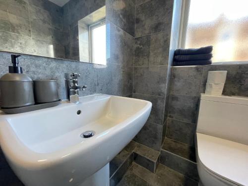 uma casa de banho com um lavatório branco e um WC. em RYAN I AIR I BNB - 458 Mill Street - Free Parking em Liverpool