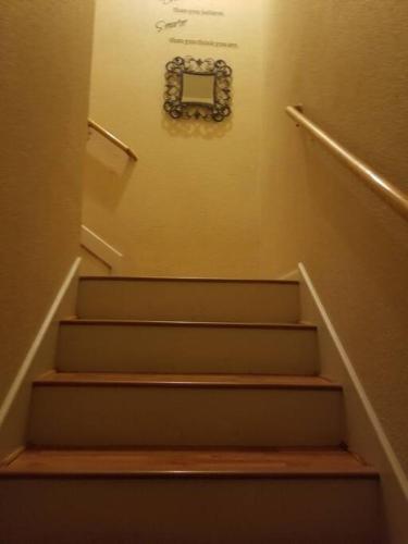 a set of stairs with a clock on the wall at Taylors Furnished Home Comforts 3bd 1 & a half bath in Temple