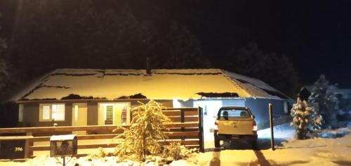 Una casa con un camión estacionado frente a ella en la nieve en Chalet Liwen en San Martín de los Andes