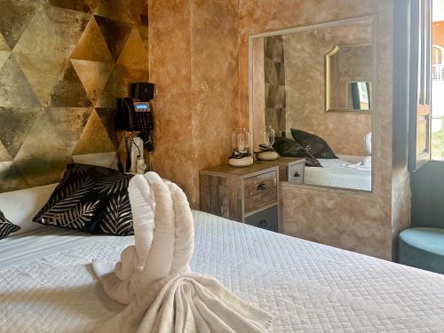 1 dormitorio con cama y espejo en Utopía Alicante - Adults Experience en Alicante