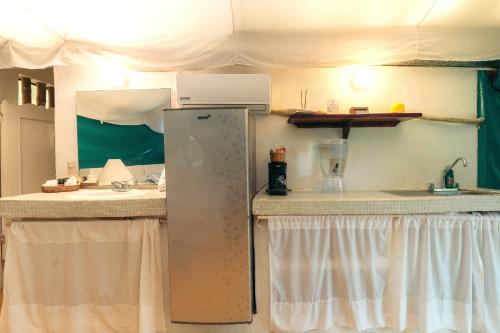 a kitchen with a refrigerator and a sink at Junto al Rio Bungalows & Suites in Sayulita