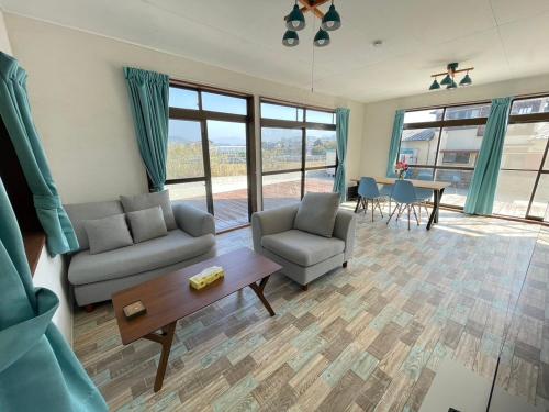 a living room with a couch and chairs and a table at Itoshima Beach House in Itoshima
