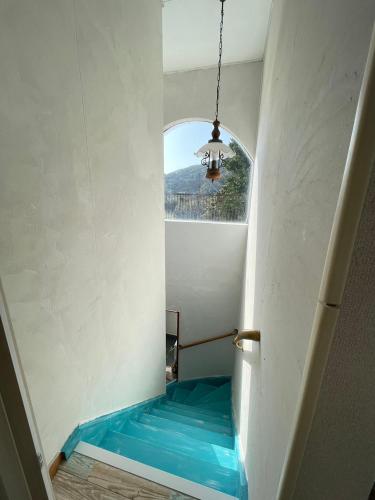 a hallway with a blue bench in a room with a window at Itoshima Beach House in Itoshima