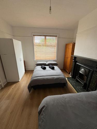 a bedroom with two beds and a fireplace at Very Nice Triple Room at 2 Iveragh Rd-5 in Dublin