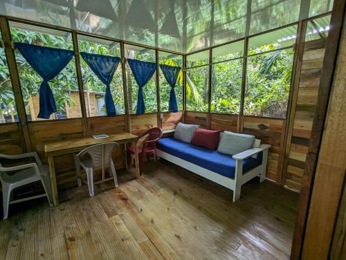 a room with a blue couch in a room with windows at Arboura Eco Cabins in Uvita