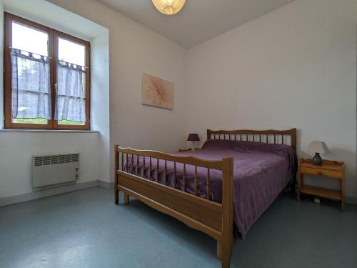 une chambre avec un lit en bois et une fenêtre dans l'établissement Maison indépendante et spacieuse près de Saint-Privat-d'Allier - FR-1-582-3, à Saint-Privat-dʼAllier