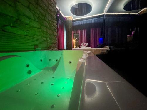a bathroom with a tub with green water at Utopía Alicante - Adults Experience in Alicante
