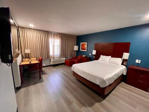 um quarto com uma cama e uma parede azul em Portside Inn & suites em San Pedro