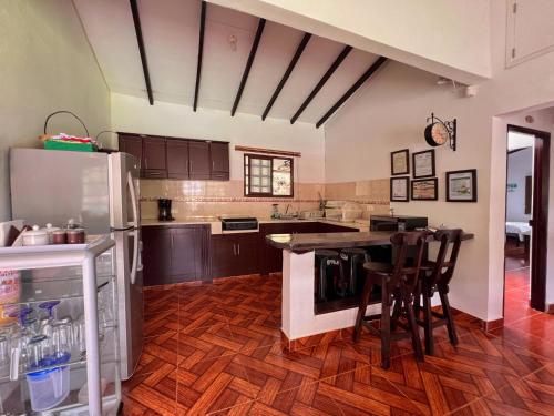 a kitchen with a refrigerator and a table with chairs at Paraiso Cocora in Salento
