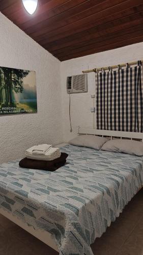 a bedroom with a large bed with a fan at Casinha Aconchegante no 3° Melhor Clima do Mundo. in Miguel Pereira