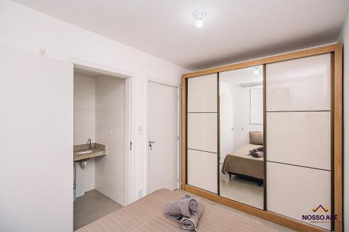 a bedroom with a mirror and a bed at Nosso Apê Teixeiras: 2/4 | Garagem | Acessível NA812T in Juiz de Fora