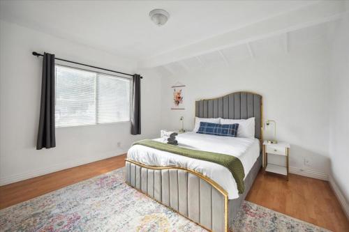 ロサンゼルスにあるChic Boho Retreat - Pool, Patio, Mini Golf & Arcade, Mins from Universal Studios!の大きなベッドと窓のある寝室