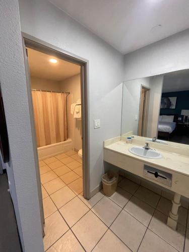 a bathroom with a sink and a mirror at Portside Inn & suites in San Pedro