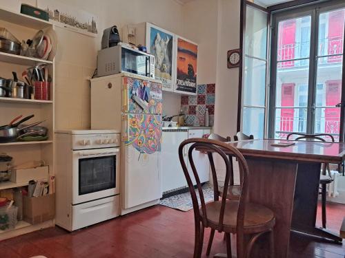 eine Küche mit einem Tisch und einem weißen Kühlschrank in der Unterkunft À côté du lac in Vevey