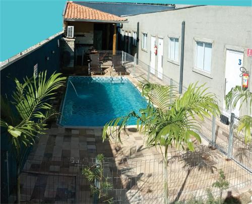 una piscina en un patio junto a un edificio en OLÍMPIA APARTS Kitnet com cozinha e banheiro privativo PISCINA AQUECIDA, en Olímpia