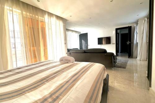 a bedroom with a bed and a living room at Grand Appartement Agdal Centre I Suite & Billard in Rabat