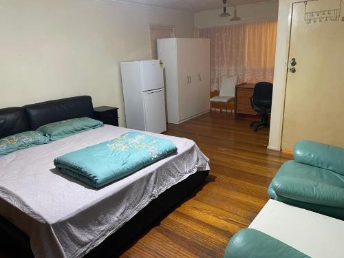 una camera con letto, frigorifero e sedia di K. A hundred meters is equivalent to a tram station homestay and king bed a Melbourne