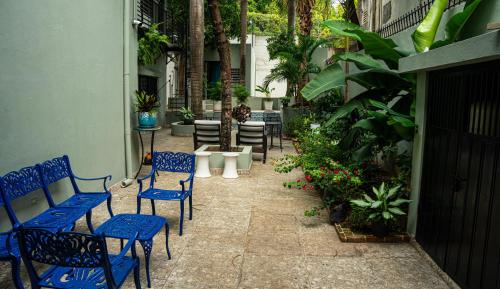 a patio with blue chairs and tables and plants at Hotelito Bonito Eli & Edw in Santo Domingo