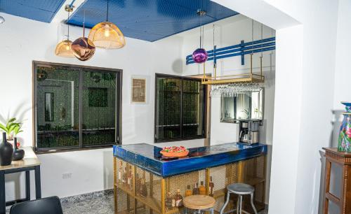 a kitchen with a blue counter and two windows at Hotelito Bonito Eli & Edw in Santo Domingo