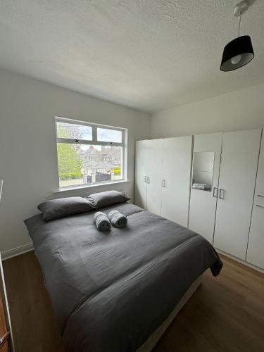 Nice Triple Room at 2 Iveragh Rd-7 في دبلن: غرفة نوم بسرير كبير مع نافذة