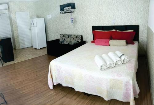 um quarto com uma cama grande com duas toalhas em OLÍMPIA APARTS Kitnet com cozinha e banheiro privativo PISCINA AQUECIDA em Olímpia