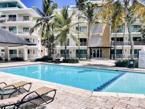 una piscina frente a un edificio con palmeras en Relax in Punta Cana, en Punta Cana