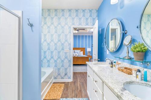 a blue bathroom with a tub and a sink at Half Shell Hideaway in Port Saint Joe