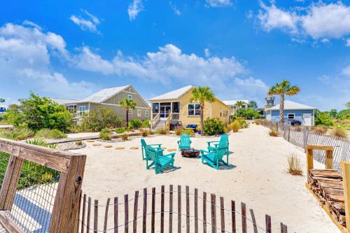 a patio with blue chairs and a fence at Half Shell Hideaway in Port Saint Joe